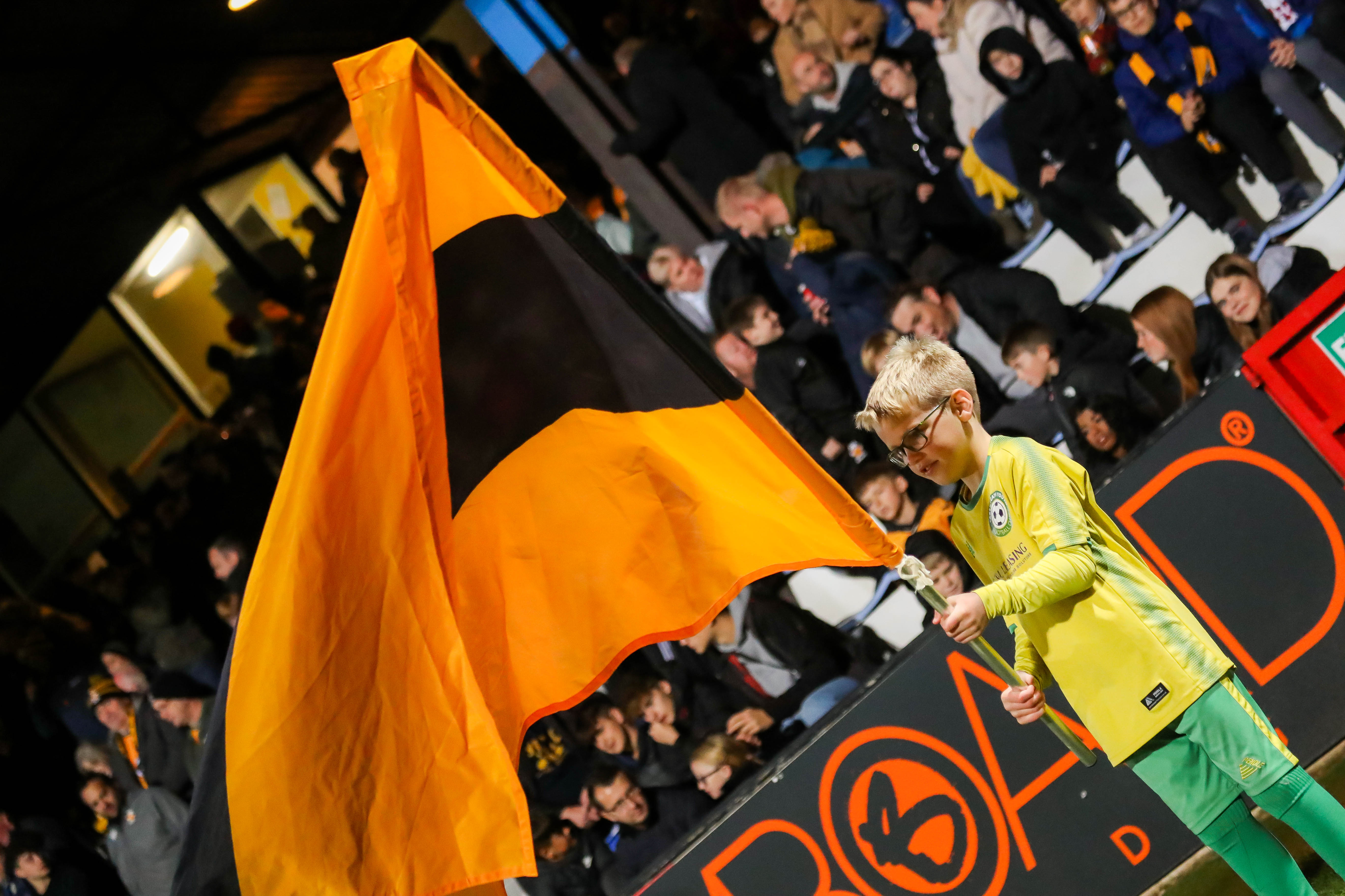 A young supporter holds up a flag during the guard of honour