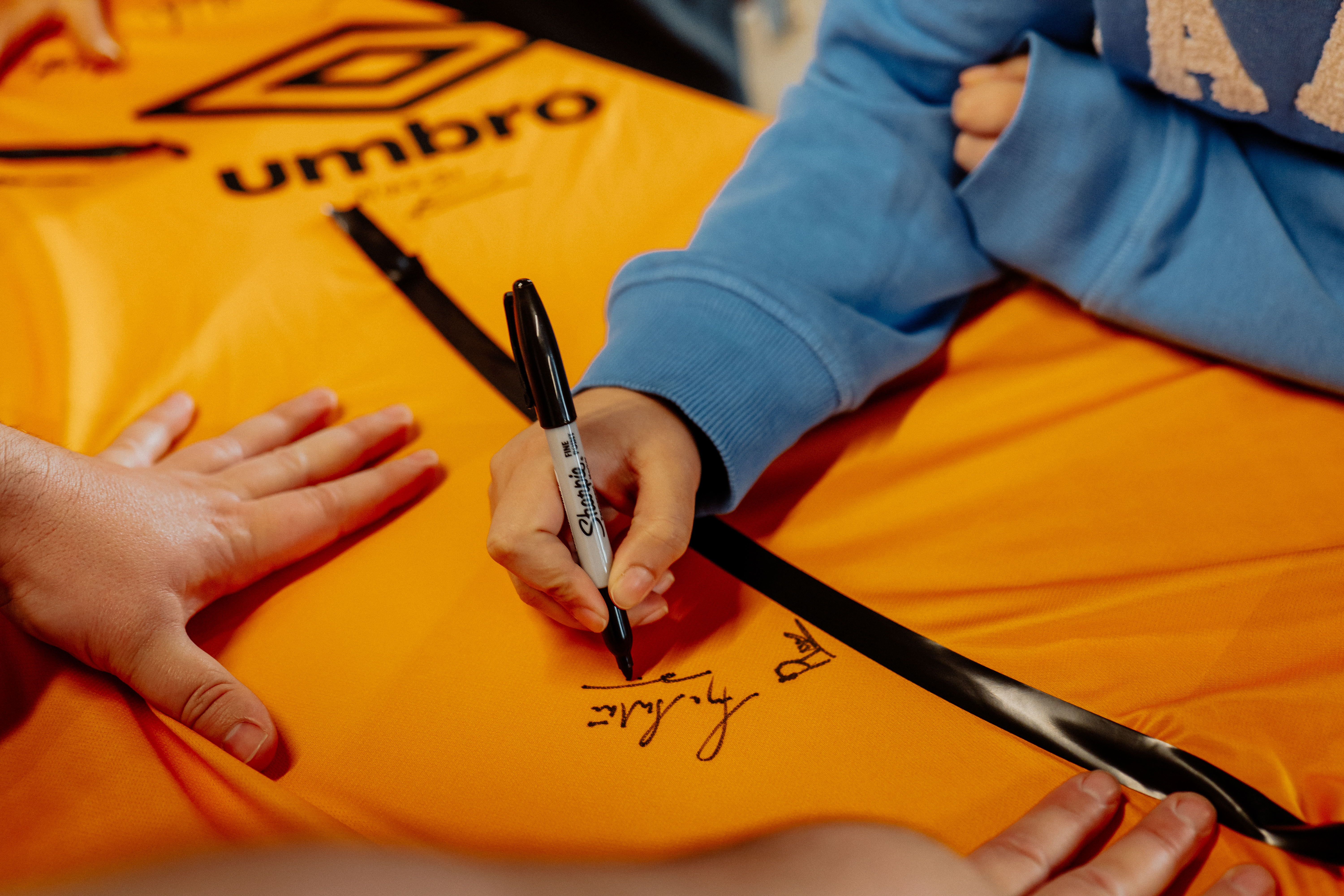 People signing a giant Cambridge United shirt