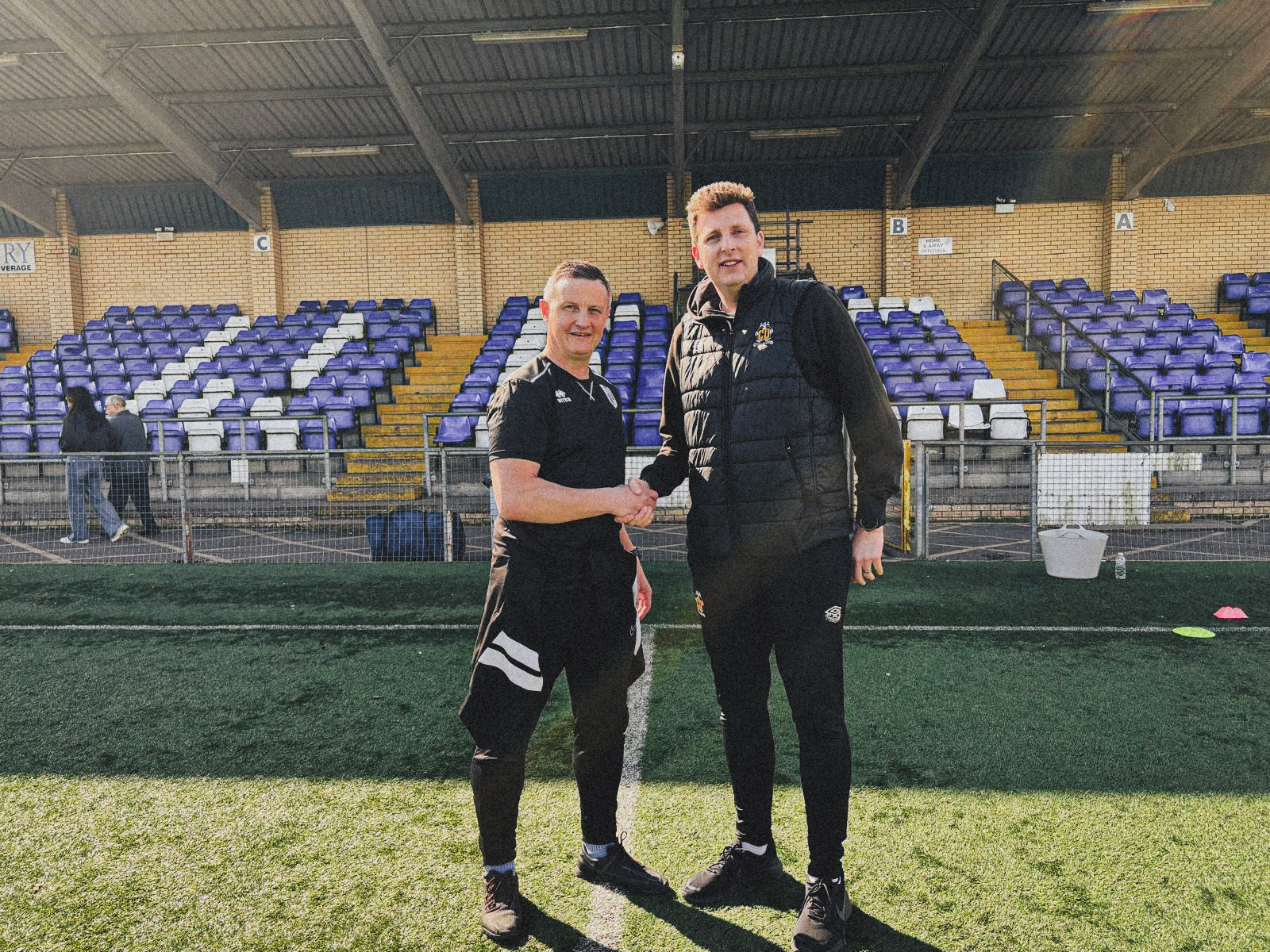 Jake Hammond of Cambridge United Academy shakes hands with Phil Pledger of Ware FC 