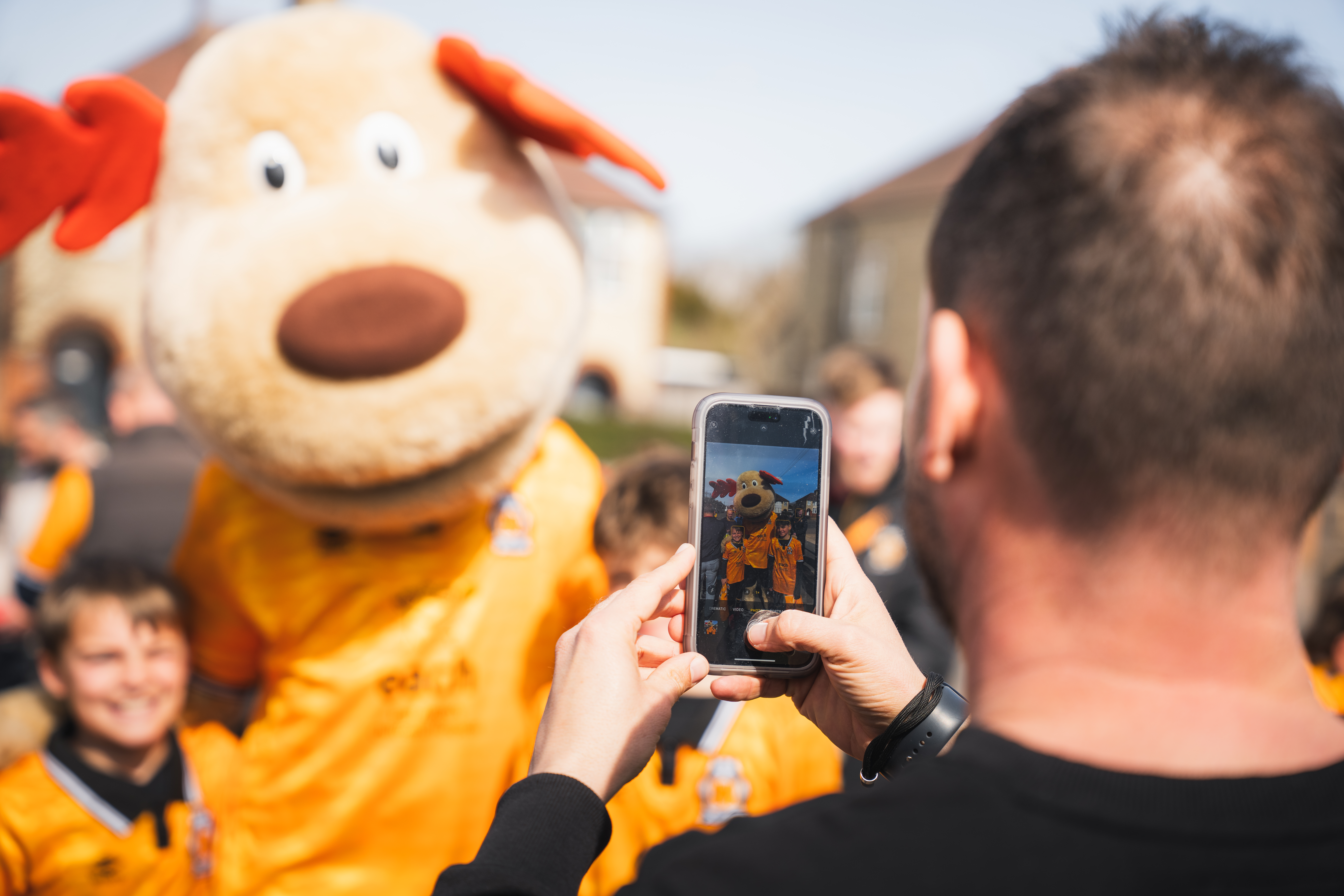 Supporters take a photo with Marvin the Moose