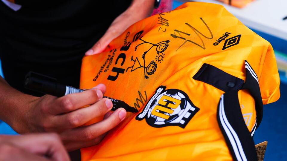 Close up of players signing a shirt