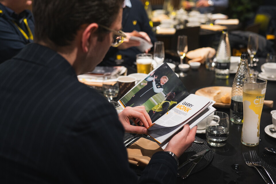 A supporter reading the Matchday Programme