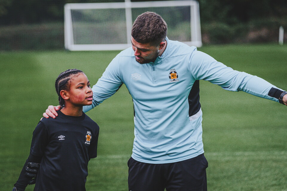 A young Cambridge United Academy player and their coach