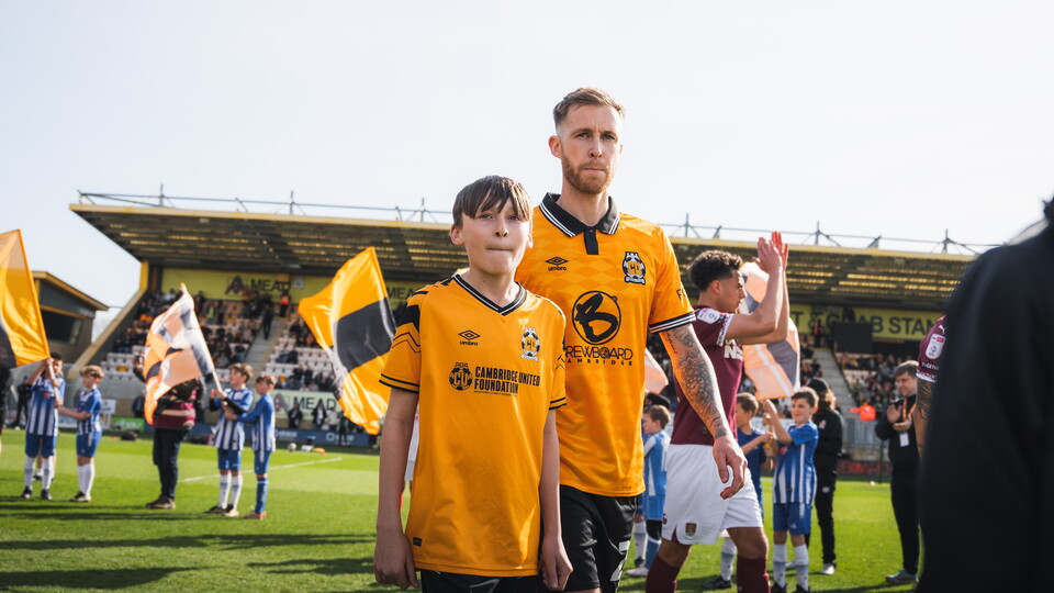 A mascot walks out with Ben Stevenson