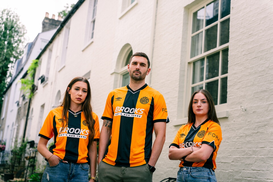 Lauren Rouse, Greg Taylor and Alysha Stojko-Down wearing the 25/26 shirt