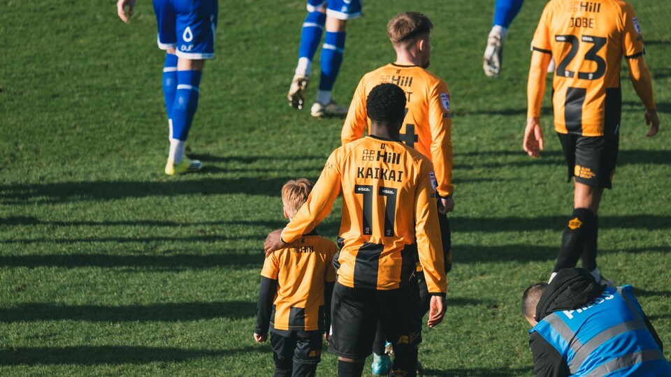 A mascot walking out with Sullay Kaikai