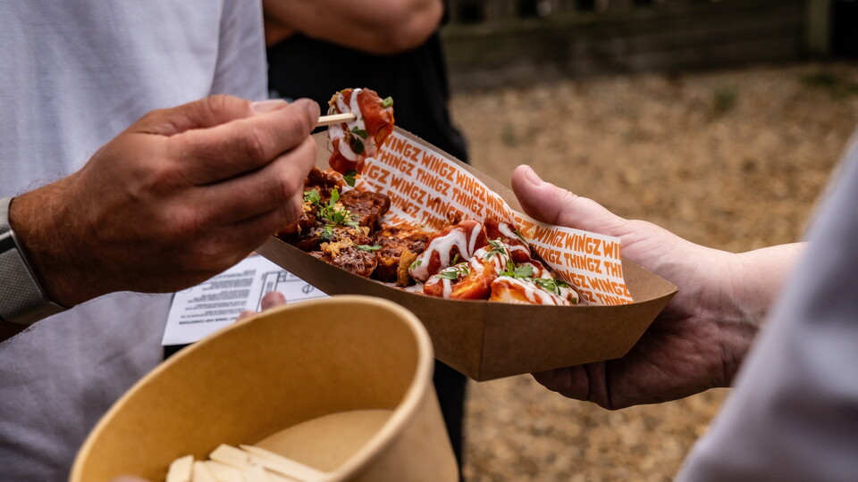 A close up of a fan eating from the United Fried Chicken food outlet