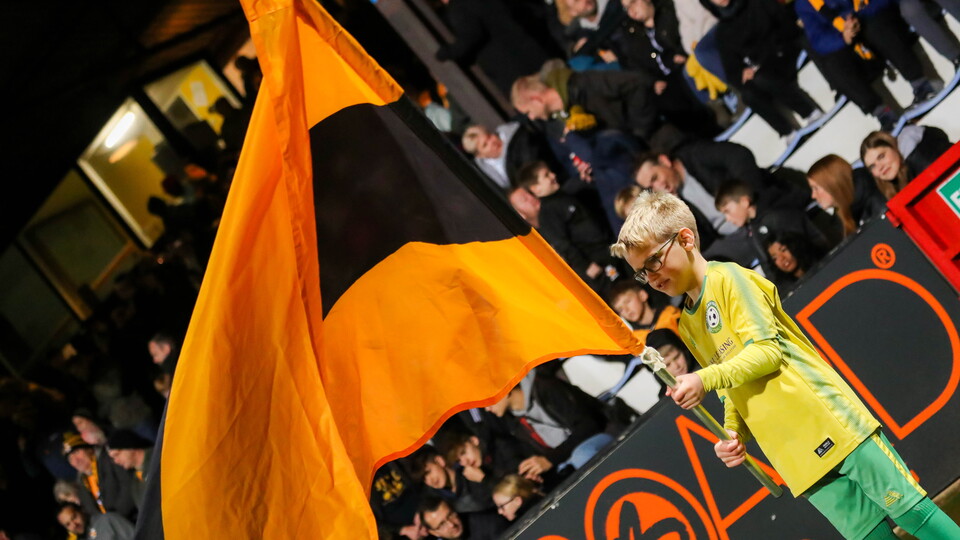 A young supporter holds up a flag during the guard of honour