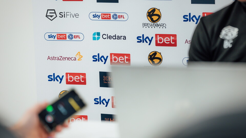 A close-up of the Club's interview backdrop board