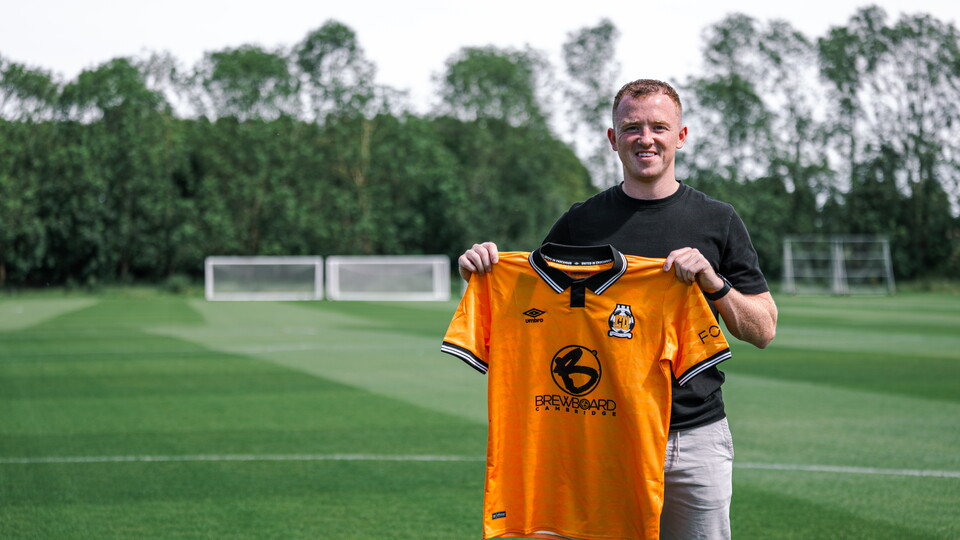 Shayne Lavery holds the Cambridge United shirt