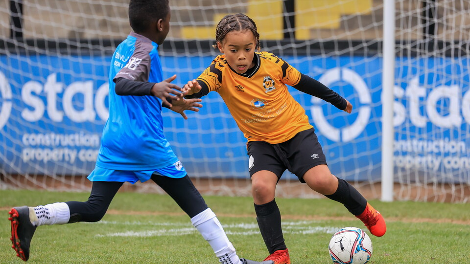 A Cambridge United Academy player takes on his opposition