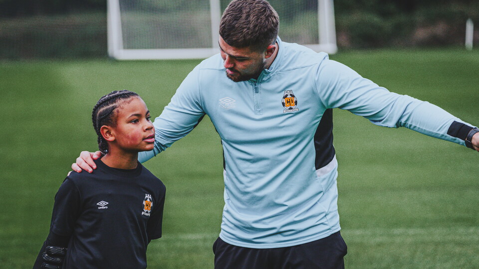 A young Cambridge United Academy player and their coach