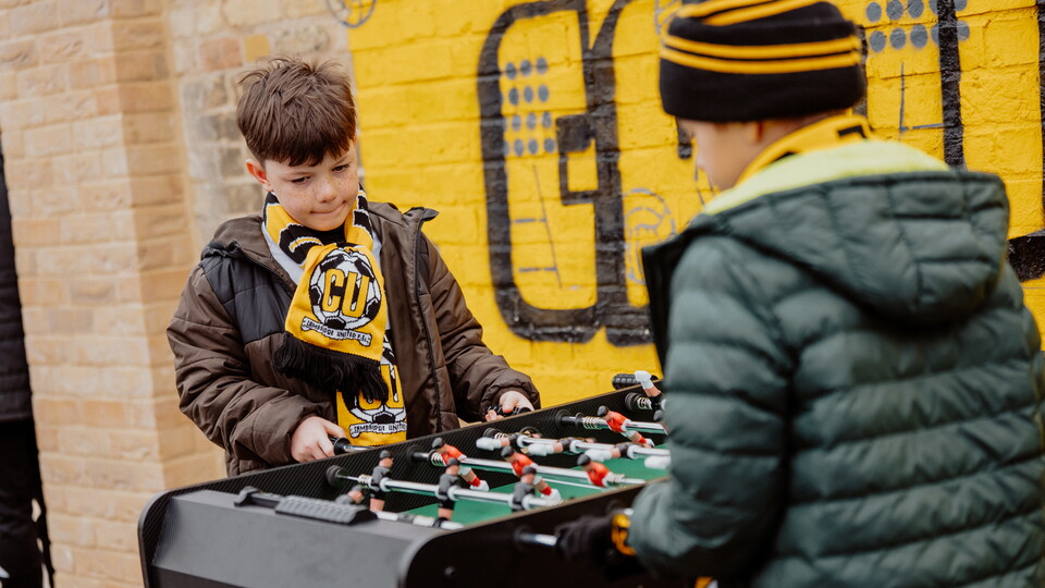 Young supporters playing Table Football at the Cledara Abbey Stadium