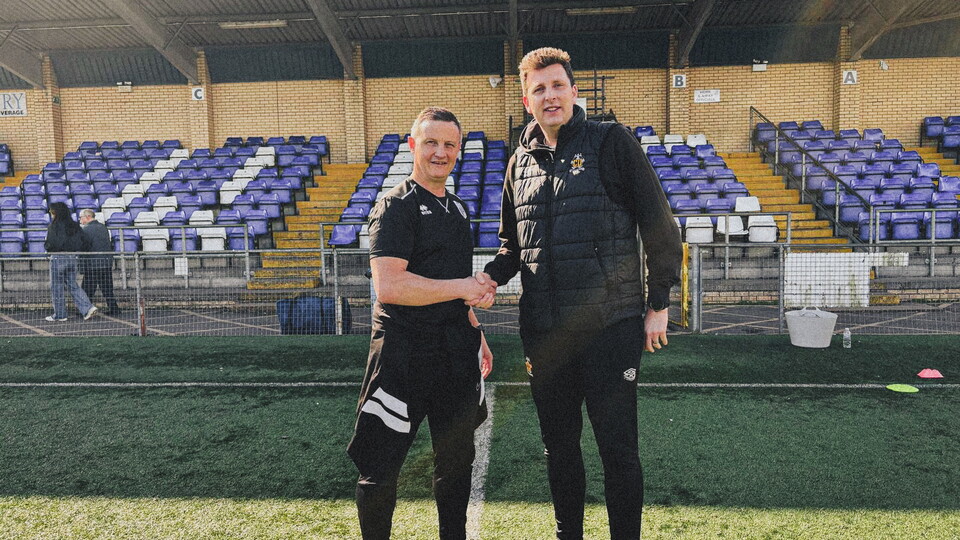 Jake Hammond of Cambridge United Academy shakes hands with Phil Pledger of Ware FC 