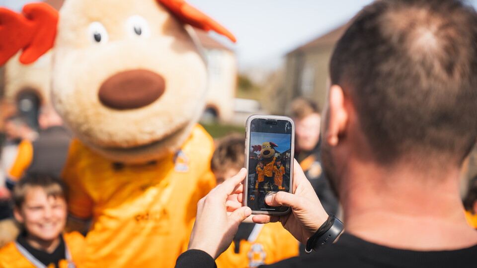 Supporters take a photo with Marvin the Moose