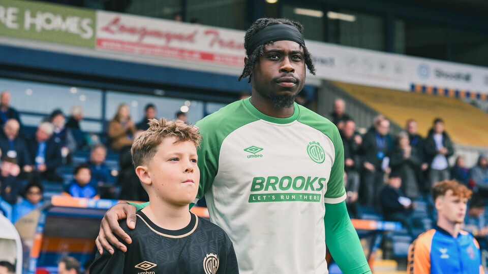 A young mascot walks out with Pelly Ruddock Mpanzu