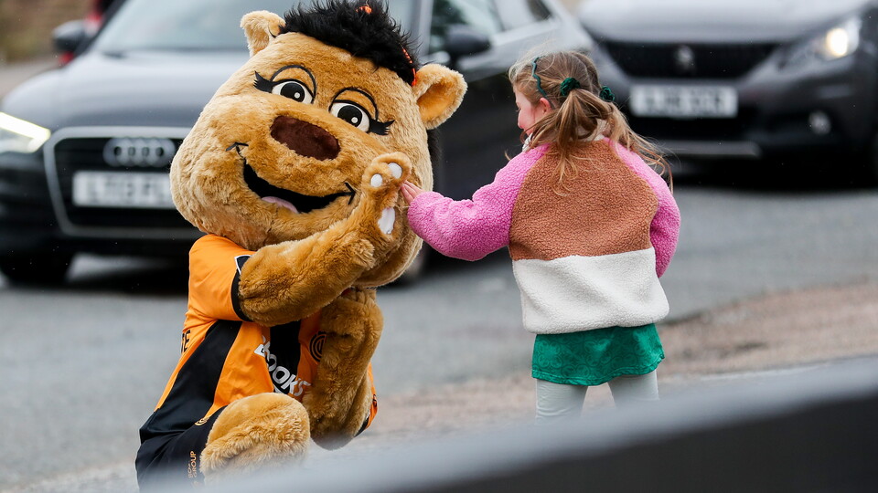 Amber the Moose high fives a fan
