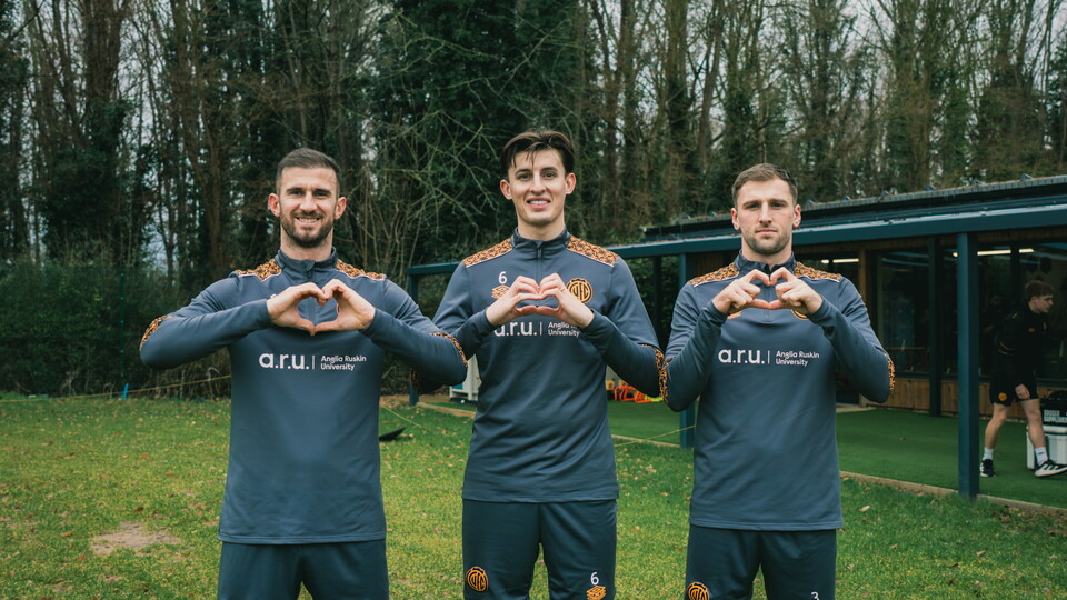 Cambridge United players showing the heart logo
