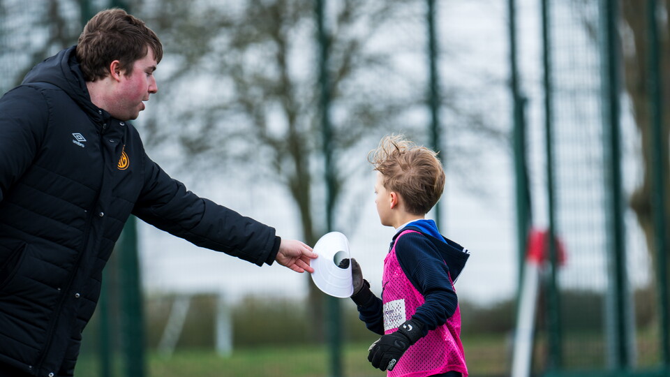 A Soccer Schools coach with a child
