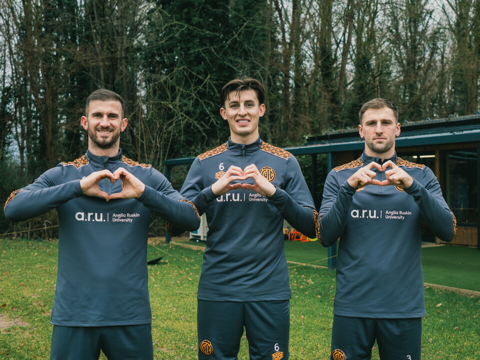 Cambridge United players showing the heart logo